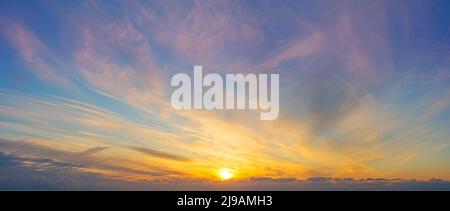 Panoramablick auf den Himmel mit verschiedenen Arten von Wolken gradienten von der Abendsonne aus dem Horizont beleuchtet Stockfoto