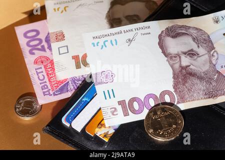 Schwarzes Leder-Etui mit Geld. 1000 Hryven Banknote Nahaufnahme. Krise, Ertrag, Wachstum, Verlust, Diebstahl Entdeckung Stockfoto