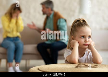 Eltern Haben Streit, Während Unglückliche Kleine Tochter Zu Hause Sitzt Stockfoto