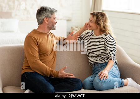 Fröhliches Paar Mittleren Alters, Das Zu Hause Redet Und Flirtet Stockfoto