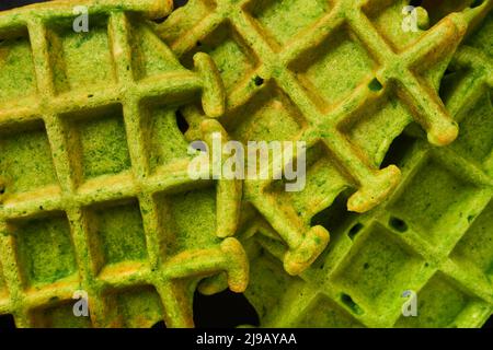 Herzhafte grüne Waffeln Textur Hintergrund. Nahaufnahme von dünnen heißen Pfannkuchen Bild. Maslenitsa Essen. Draufsicht. Stockfoto