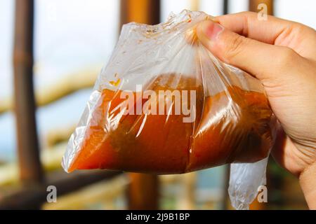 Ein typischer Snack aus Bandung, Indonesien. Fischbällchen alias Baso ikan mit würziger Suppe in Plastik verpackt. Verarbeitetes Fleisch, eines der krebsverursachenden Lebensmittel Stockfoto