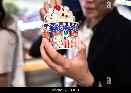Eis-Terrine in der Hand einer Frau auf einem städtischen Straßenmarkt in der Nacht Stockfoto