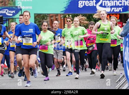 Freya Lewis (Mitte) trifft auf mehr als 20.000 Fahrer beim Great Manchester Run durch das Stadtzentrum von Manchester, um den fünfjährigen Jahrestag des Bombenanschlags in der Manchester Arena zu feiern. Frau Lewis, 19, die nach mehreren Verletzungen, Brüchen und Verbrennungen beim Bombenanschlag wieder gehen lernte, wird für die Royal Manchester Children's Hospital Charity Rennen, die ihr das Leben rettete. Bilddatum: Sonntag, 22. Mai 2022. Stockfoto