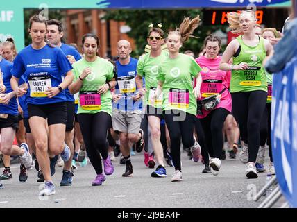 Freya Lewis (Mitte) trifft auf mehr als 20.000 Fahrer beim Great Manchester Run durch das Stadtzentrum von Manchester, um den fünfjährigen Jahrestag des Bombenanschlags in der Manchester Arena zu feiern. Frau Lewis, 19, die nach mehreren Verletzungen, Brüchen und Verbrennungen beim Bombenanschlag wieder gehen lernte, wird für die Royal Manchester Children's Hospital Charity Rennen, die ihr das Leben rettete. Bilddatum: Sonntag, 22. Mai 2022. Stockfoto