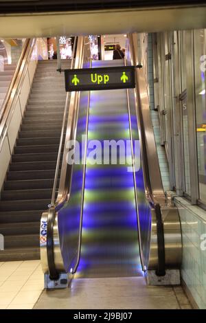 Rolltreppe mit farbigem Licht in der U-Bahn-Station (Tunnelbana) in Stockholm, Schweden; Schild oben Stockfoto