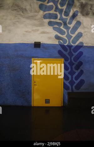 Gelbe Tür in blauer (und weißer) Felswand in der U-Bahnstation T-Centralen (Hauptbahnhof) in Stockholm Stockfoto