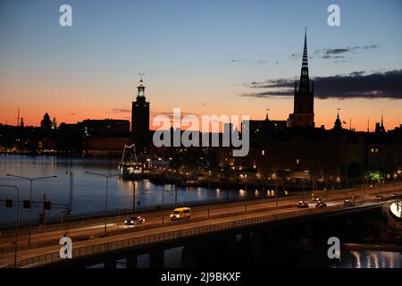 Blick über die Stadt Stockholm, die Hauptstadt Schwedens, von Slussen aus während der Goldenen Stunde über das Wasser. Farben und Wolken am Himmel Stockfoto