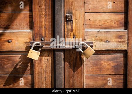 Holztür mit zwei Vorhängeschlössern verschlossen, Geschäft geschlossen Stockfoto