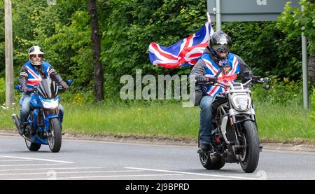 Milton Keynes, Großbritannien, 22.. Mai 2022. Die Reiter der Distinguished Gentleman’s Ride reiten von Milton Keynes nach Bedford, gekleidet in Union Jack Westen und mit einer Union Jack Flagge Stockfoto