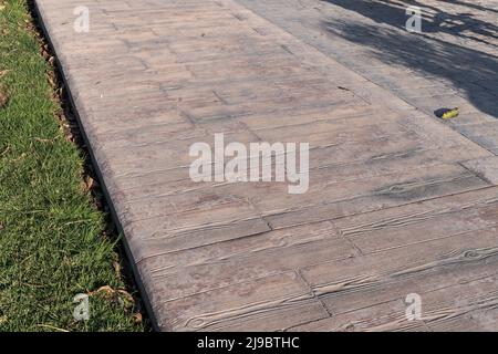 Gestempelte Betonpflaster im Freien, Holzlatten Muster, Bodenbelag außen, dekorative Textur von Zement Pflasterstreifen Stockfoto
