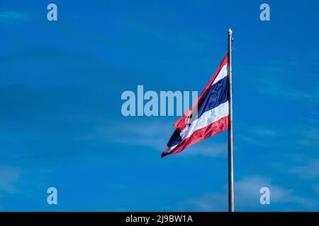 Nationalflagge Thailands auf dem Pol gegen den blauen Himmel der Natur. Stockfoto