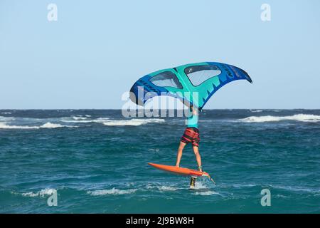 BOCA GRANDI, ARUBA - 17. DEZEMBER 2020: Person mit einem Naish Wing-Surfer-Drachen auf einem Foilboard am Boca Grandi Strand auf Aruba Stockfoto