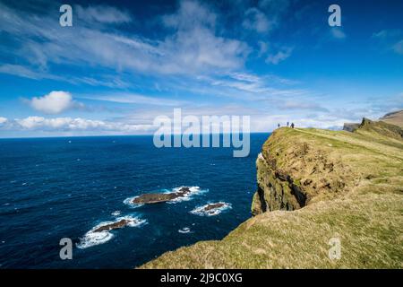 Wanderer am Rande einer Klippe in Mykines auf den Färöern. Stockfoto