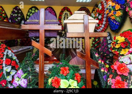 Innenraum des Raumes mit Bestattungszubehör. Geschäft mit Särgen, Beerdigungskränzen und Blumen. Stockfoto