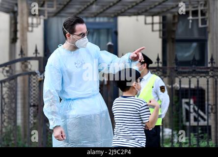 (220522) -- TIANJIN, 22. Mai 2022 (Xinhua) -- Iarroumets Jonathan gibt einem Kind am Nukleinsäuretestplatz einer Gemeinde im Bezirk Nankai, im nordchinesischen Tianjin, die Richtung vor, 22. Mai 2022. Die nordchinesische Gemeinde Tianjin erlebte kürzlich ein Wiederaufleben des COVID-19. Iarroumets Jonathan, ein Belgier, der seit einem Jahrzehnt in Tianjin lebt, meldete sich als Freiwilliger in seiner Wohngemeinde an. Jonathan entwickelte schon in jungen Jahren eine tiefe Vorliebe für die chinesische Kultur und kam nach seinem College-Abschluss nach China, um dort zu leben. Tianjin ist seine zweite Heimatstadt geworden. „Jeder ist damit beschäftigt, gegen die zu kämpfen Stockfoto