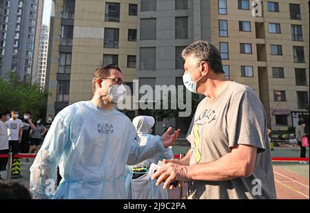 (220522) -- TIANJIN, 22. Mai 2022 (Xinhua) -- Iarroumets Jonathan (L) spricht mit einem ausländischen Bewohner am Nukleinsäuretestplatz einer Gemeinde im Bezirk Nankai, im nordchinesischen Tianjin, 22. Mai 2022. Die nordchinesische Gemeinde Tianjin erlebte kürzlich ein Wiederaufleben des COVID-19. Iarroumets Jonathan, ein Belgier, der seit einem Jahrzehnt in Tianjin lebt, meldete sich als Freiwilliger in seiner Wohngemeinde an. Jonathan entwickelte schon in jungen Jahren eine tiefe Vorliebe für die chinesische Kultur und kam nach seinem College-Abschluss nach China, um dort zu leben. Tianjin ist seine zweite Heimatstadt geworden. „Jeder ist beschäftigt mit Kämpfen Stockfoto