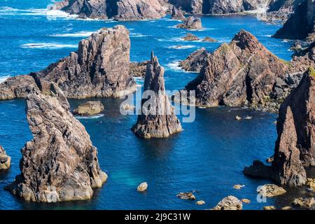 In den Mangersta Sea Stacks erheben sich Felsaufschlüsse aus dem strahlend blauen Meer. Stockfoto