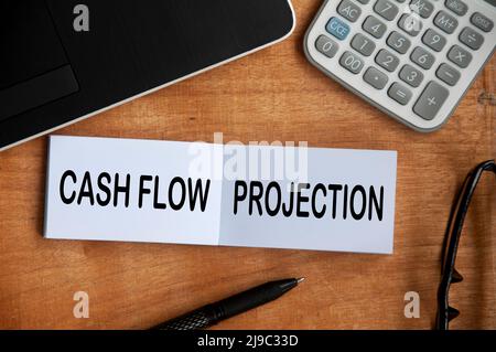 Cashflow-Projektion Text auf Notizblock mit Rechner, Stift und Laptop-Hintergrund. Geschäftskonzept Stockfoto