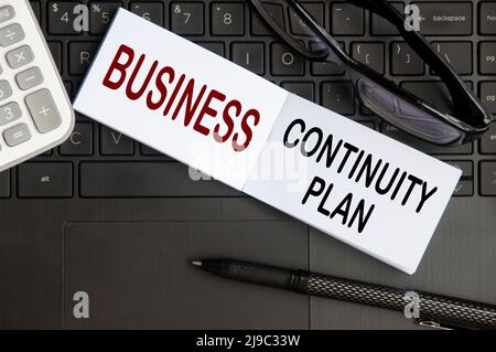 Business-Continuity-Plan-Text auf Notizblock mit Brille, Stift und Laptop-Hintergrund. Geschäftskonzept Stockfoto