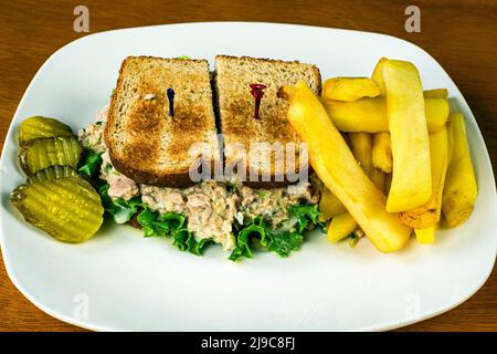 Thunfisch-Salat-Sandwich serviert mit Steak Potaoe Pommes und pickl;e Stockfoto