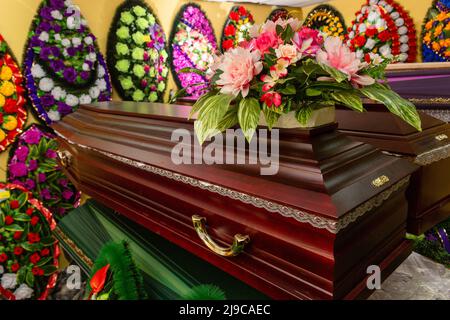 Innenraum des Raumes mit Bestattungszubehör. Geschäft mit Särgen, Beerdigungskränzen und Blumen. Stockfoto