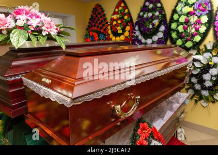 Innenraum des Raumes mit Bestattungszubehör. Geschäft mit Särgen, Beerdigungskränzen und Blumen. Stockfoto