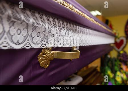 Innenraum des Raumes mit Bestattungszubehör. Geschäft mit Särgen, Beerdigungskränzen und Blumen. Stockfoto