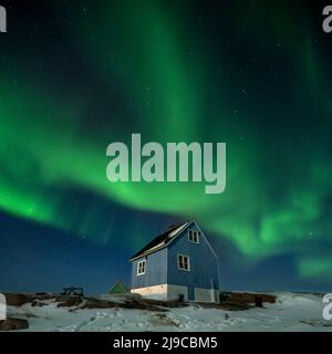 Die Nordlichter über einem blauen Haus im Dorf Oqaatsut in Westgrönland. Stockfoto