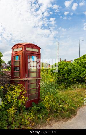 Eine ausgediente alte Retro UK rote Telefonbox in Bacton, North Norfolk, UK Stockfoto