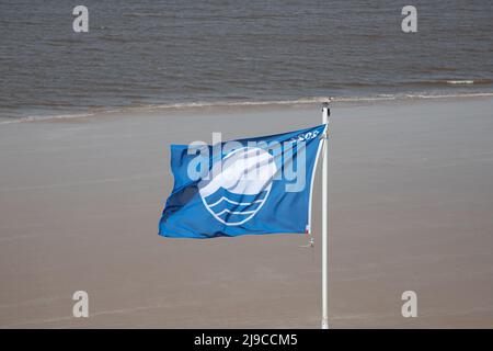 Die prestigeträchtige Blaue Flagge fliegt an einem windigen Frühlingstag am Sheringham Beach in North Nofolk, Großbritannien Stockfoto