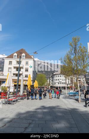 Chur, Schweiz, 11. April, 2022 Menschen wandern an einem sonnigen Tag im Frühling durch die Innenstadt Stockfoto