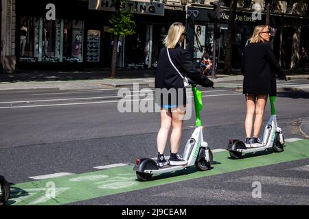 Paris, Frankreich - 21. Mai 2022 Menschen Rollen mit einem Elektroroller in den Straßen von Paris, die mit einem kleinen Utility-Verbrennungsmotor arbeiten Stockfoto