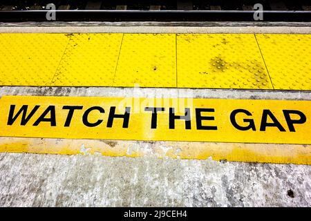 Schild „Watch the Gap“ auf einem Bahnsteig im Bundesstaat New York, USA Stockfoto