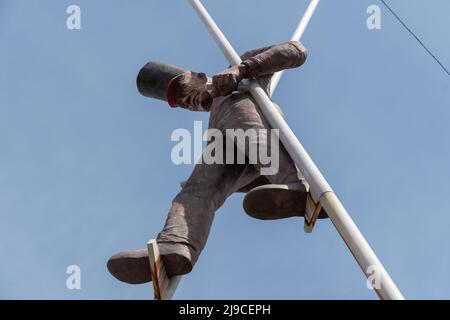 Chur, Schweiz, 11. April 2022 Skulptur eines Mannes, der auf Stelzen im Stadtzentrum läuft Stockfoto