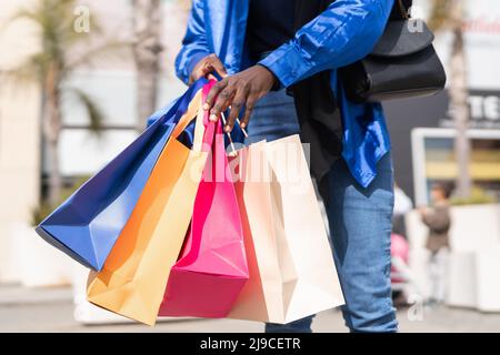 Crop schwarzen Shopper mit bunten Taschen Stockfoto