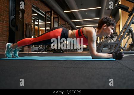 Sportler, der statische Kernübungen auf einer Yogamatte durchführt Stockfoto