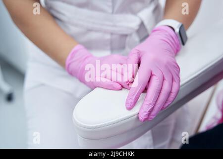 Nahaufnahme der Hände eines professionellen Kosmetikers mit Gummihandschuhen Stockfoto