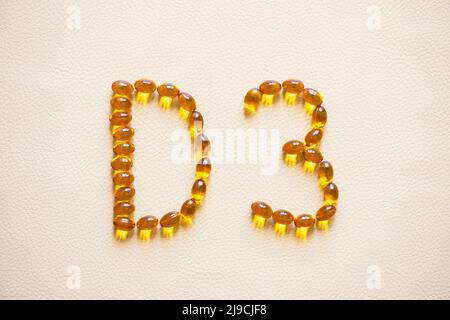 Helle Öl gelbe Pillen bilden Form D3. Vitamin D3 Kapseln. Medizinische Vitamine und Nahrungsergänzungsmittel. Selektiver Fokus. Stockfoto