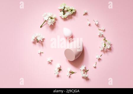 Flache Lay-Komposition mit Kosmetikartikeln und Fliederblumen auf einem rosa zarten Hintergrund. Muttertagskarte, Frauentag Stockfoto