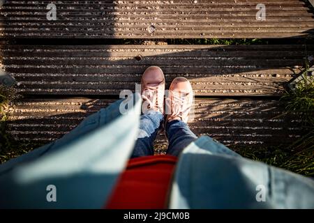 Die Füße der Person stehen auf einer Holzbrücke Stockfoto