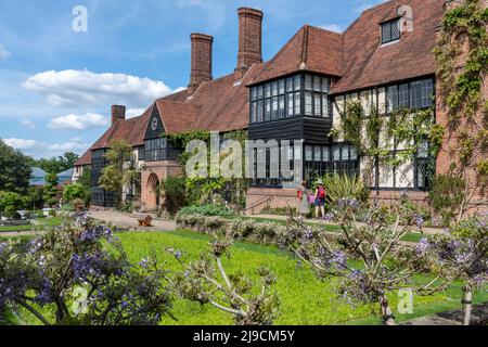 RHS Wisley Garden, das alte Laborgebäude mit Pflanzen, einschließlich blühender Glyzinien, im Mai, in Surrey, England, VEREINIGTES KÖNIGREICH Stockfoto