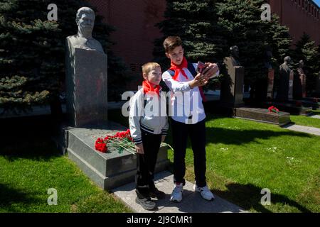 Moskau, Russland. 22.. Mai 2022. Junge Pioniere machen ein Selfie auf dem Hintergrund des Grabes des sowjetischen Führers Josef Stalin während einer Pionierzeremonie auf dem Roten Platz in Moskau, um den Beitritt zur Pioneers-Organisation und den 100.. Jahrestag der All-Union Pioneer Organization in Moskau, Russland, zu feiern. Nikolay Vinokurov/Alamy Live News Stockfoto