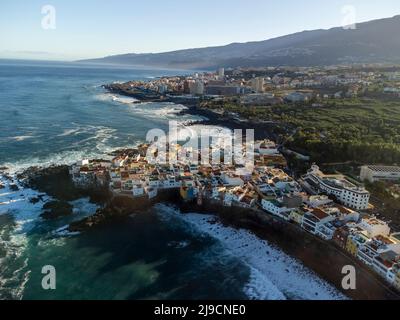 Luftaufnahme auf bunte Häuser und schwarze Lavasteine im kleinen Fischerdorf Punta Brava in der Nähe von Puerto de la Cruz, Teneriffa, Kanarische Inseln bei Sonnenaufgang Stockfoto
