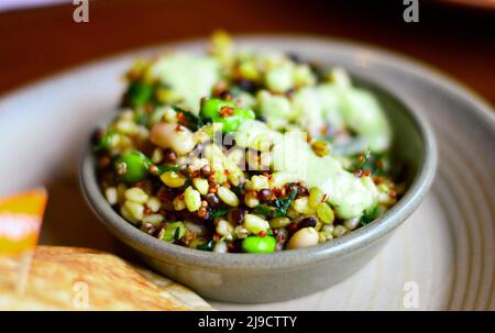 Nahaufnahme eines gesunden Superfood-Salats mit reichem Protein, einschließlich Quinoa, Avocado, Bohnen und Getreide. Stockfoto