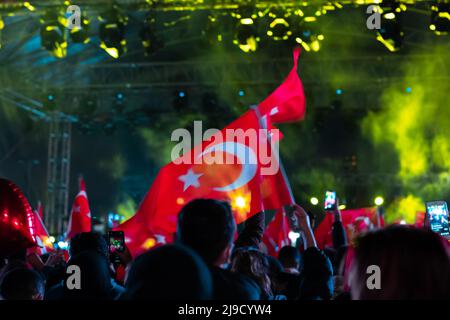 Schwenken von türkischen Flaggen bei einer Feier in der Nacht. Nationale Tage der Türkei. Bewegungsunschärfe auf den Markierungen und Unschärfe-Effekt. Stockfoto