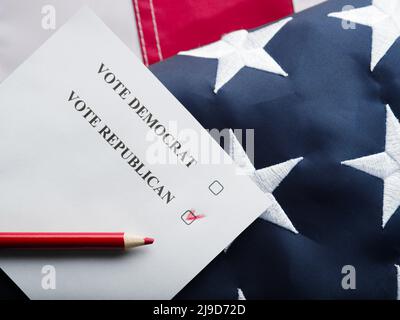 Abstimmung mit einer Marke gegenüber der Republikanischen Partei. Der Hintergrund ist die amerikanische Flagge. Nahaufnahme. Auf dem Foto befinden sich keine Personen. Farbbild. Niedrig an Stockfoto
