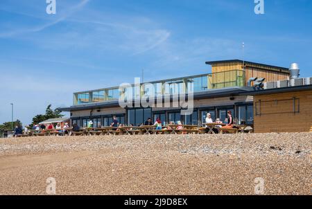 Leute saßen draußen am Strand, einem neuen Strandcafe, Strandclub und Aktivitätszentrum am Littlehampton Strand in Littlehampton, West Sussex, England, Großbritannien. Stockfoto