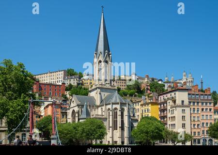 Schöner Blick auf eine Fußgängerbrücke, die in die malerische Altstadt von Lyon und die Kirche Saint George führt Stockfoto