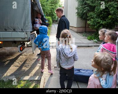 17. Mai 2022, Lemberg, Ukraine: Waisenkinder und Flüchtlingskinder in der Ukraine vermischen sich unter den wachsamen Augen der Waisenhausmitarbeiter, da Yurii Lomikovskyi, Organisator der Ukrainischen Studentenliga, Veteranen bei freiwilligen Helfern aus Großbritannien unterstützt und am 16. Mai 2022 benötigte Vorräte und Süßigkeiten für sie in ihrem Waisenhaus in Lviv abgibt. Unter den Jungen und Mädchen, die vor der brutalen Invasion in Russland, und einige davon wegen, elterlos wurden, sind einige Flüchtlingskinder, die mit ihren Eltern auf dem Gelände wohnen, die vor kurzem aus vom Krieg zerrissenen Städten in der Ukraine geflohen sind. Besuchen Sie www.en.usl.org.ua und www.ve Stockfoto